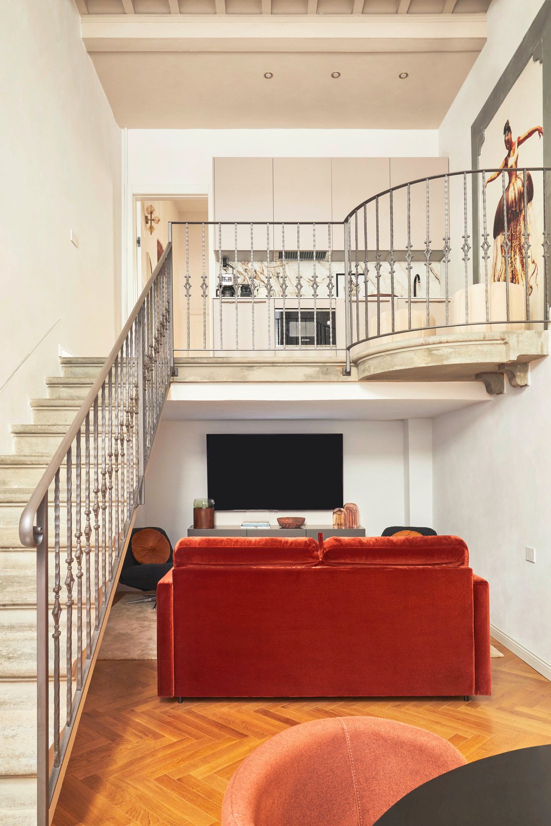 Loft con divano rosso e scala a chiocciola